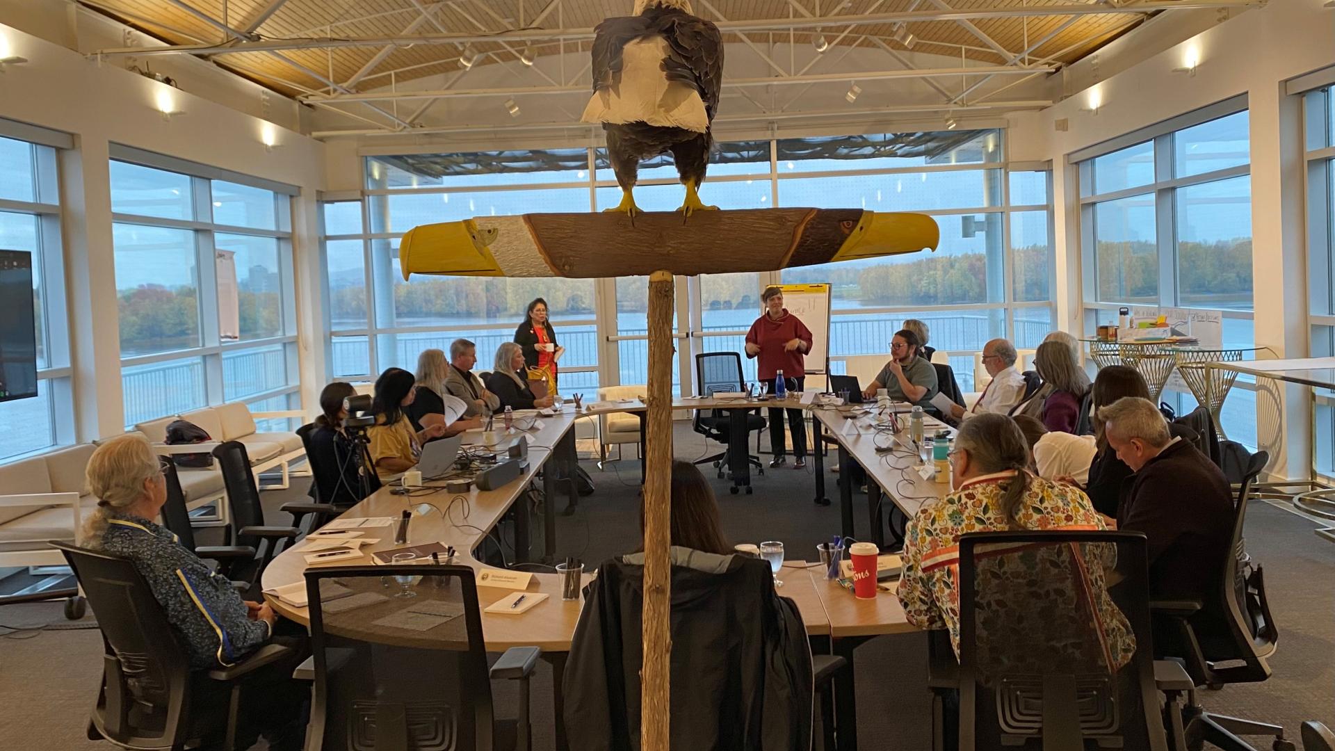 A group of people surround a meeting room table.