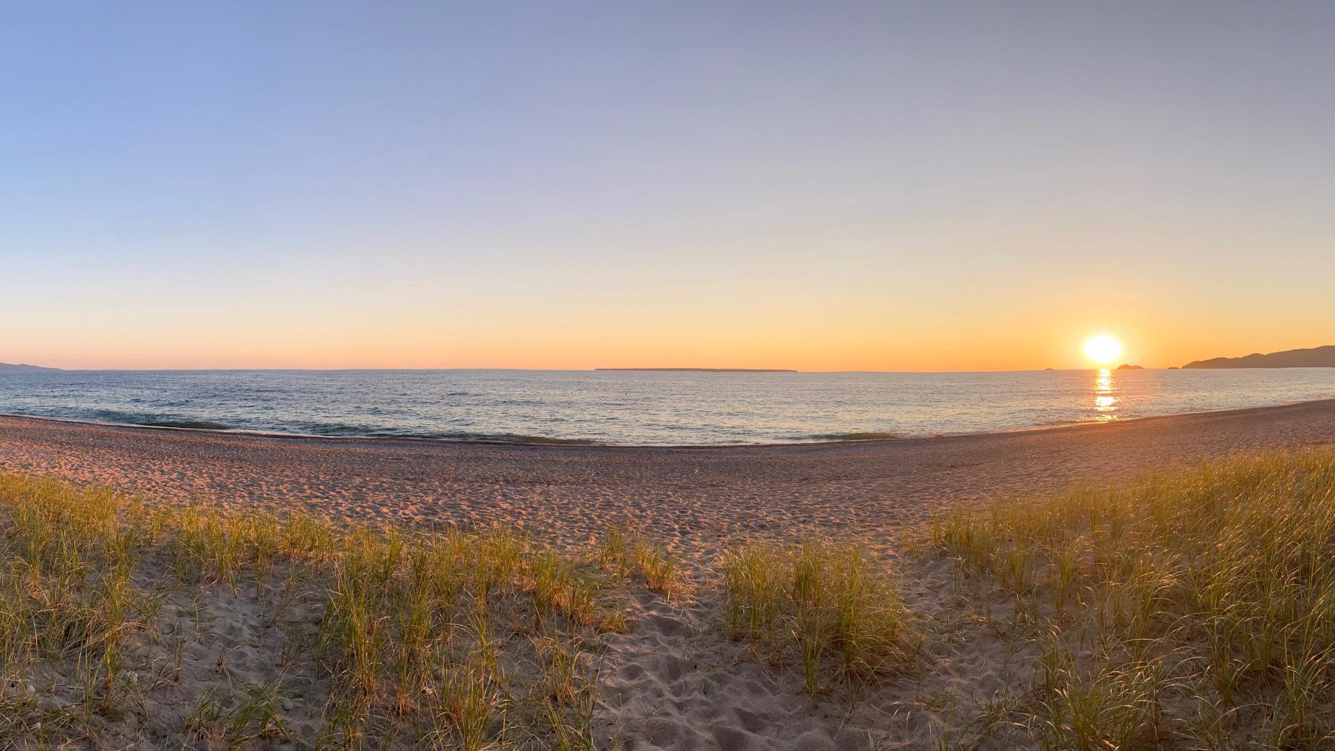 A wide angle photo of the sun on a Great Lake.