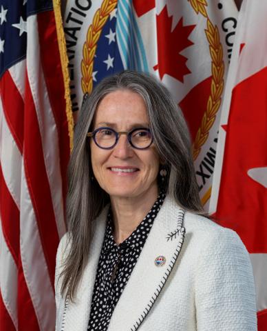 Picture of Merrell-Anne Phare with background with U.S., Canadian and IJC flags